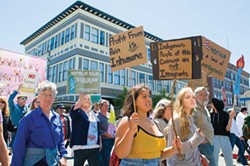 PHOTO BY MARK MCKENNA - Demonstrators march past the 10 Window Williams building in Old Town.
